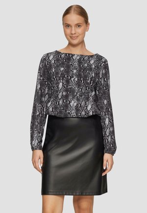 Korte langemouw blouse in zwart-wit slangenprint, gecombineerd met een zwarte leren minirok, gladde textuur, aansluitende silhouet.