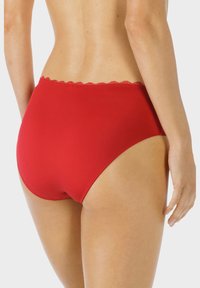 Slip rossi a vita alta realizzati in tessuto morbido, con bordo in pizzo scallop lungo la cintura. Il design offre una vestibilità aderente.