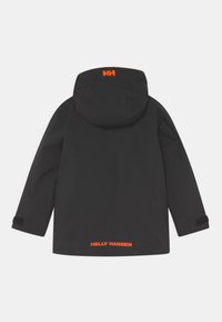 Černá voděodolná bunda s kapucí, která má na zadní straně oranžové logo Helly Hansen, suché zipy na rukávech a minimalistický design.
