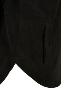 Abito in pile nero con una texture liscia. Presenta una tasca laterale e un orlo asimmetrico, creando un leggero effetto drappeggiato.