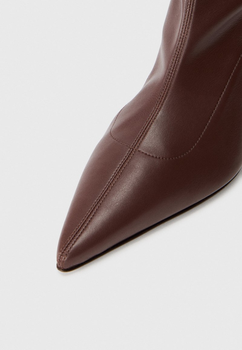 Braune Lederstiefelette mit spitz zulaufender Zehenpartie und schlankem Design. Verfügt über subtile Nähte und eine glatte Oberfläche, die ein gepflegtes Erscheinungsbild betont.