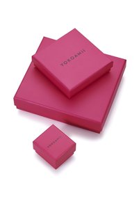 Tres cajas de regalo rosas de diferentes tamaños están apiladas. Cada una tiene un acabado suave y mate, con el texto "YOKOAMii" en negro.