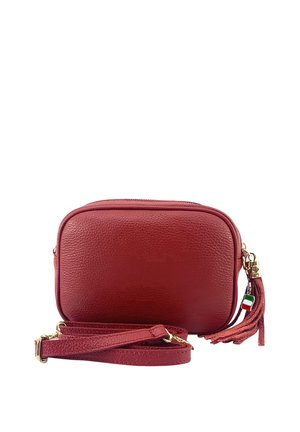 Compact rode leren crossbodytas met verstelbare riem, gouden hardware en een bedeltje met kwastje met een label van de Italiaanse vlag.