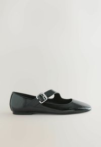 Black patent leather flat shoe with a cutout design and a side strap, featuring a metallic buckle. Pointed toe and smooth texture.
