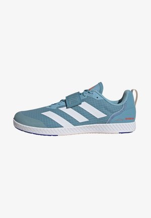 Chaussure de sport bleue avec un design à trois rayures blanches, dessus texturé, fermeture à lacets, pointe renforcée et talon moulé. Comprend un détail de marque.