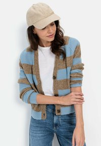 Stribet cardigan i brun og lyseblå strik med knaplukning foran og ribbede manchetter. Kombination med en hvid t-shirt og denim jeans.