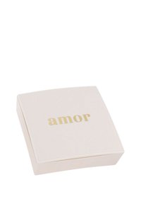 Scatola quadrata, rosa pallido, con una superficie liscia, recante la parola "amor" in lettere dorate sul coperchio. Design minimalista.