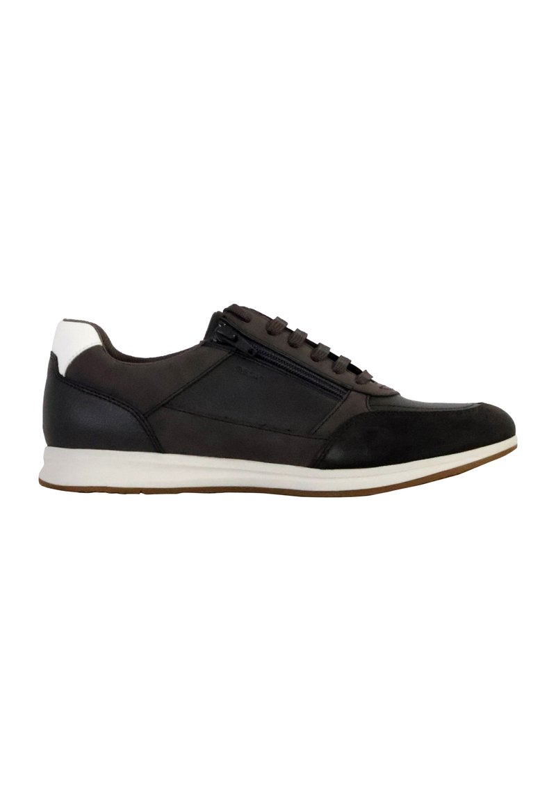 Zapatilla negra con cuero texturizado y detalles en ante. Presenta una tapa en el talón blanca y una cremallera lateral. Suela de goma. Diseño atlético clásico.