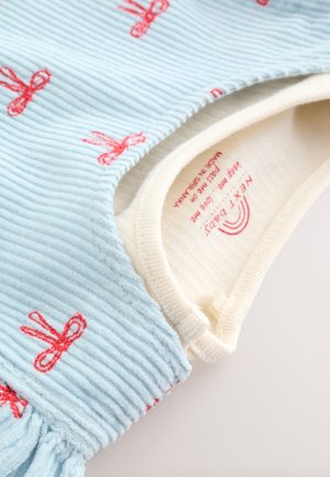 Modrá manšestrová látka s červenou výšivkou mašle. Obsahuje krémově zbarvený, žebrovaný výstřih. Měkká textura, přiléhavý střih, žádná viditelná zapínání.