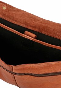 Braune Ledertasche mit glatter Außenfläche und einem weichen, wildlederartigen Klappdeckel. Das Innere verfügt über ein dunkles Futter und ein mit Reißverschluss versehenes Fach.