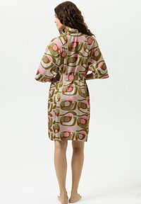 Korte jurk in een mix van pasteltinten met geometrische patronen. Gemaakt van lichtgewicht stof, voorzien van een bindceintuur en mouwen tot op de elleboog.