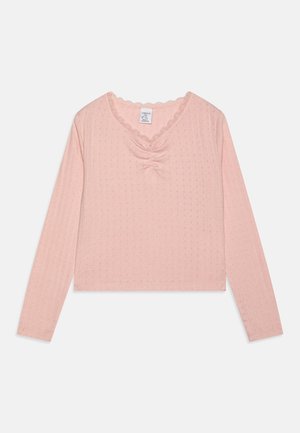 Helles rosa langärmliges Oberteil mit V-Ausschnitt, gerafftem Mittelpunkt und gewelltem Spitzenbesatz. Hergestellt aus strukturiertem Stoff mit kleinen Mustern.