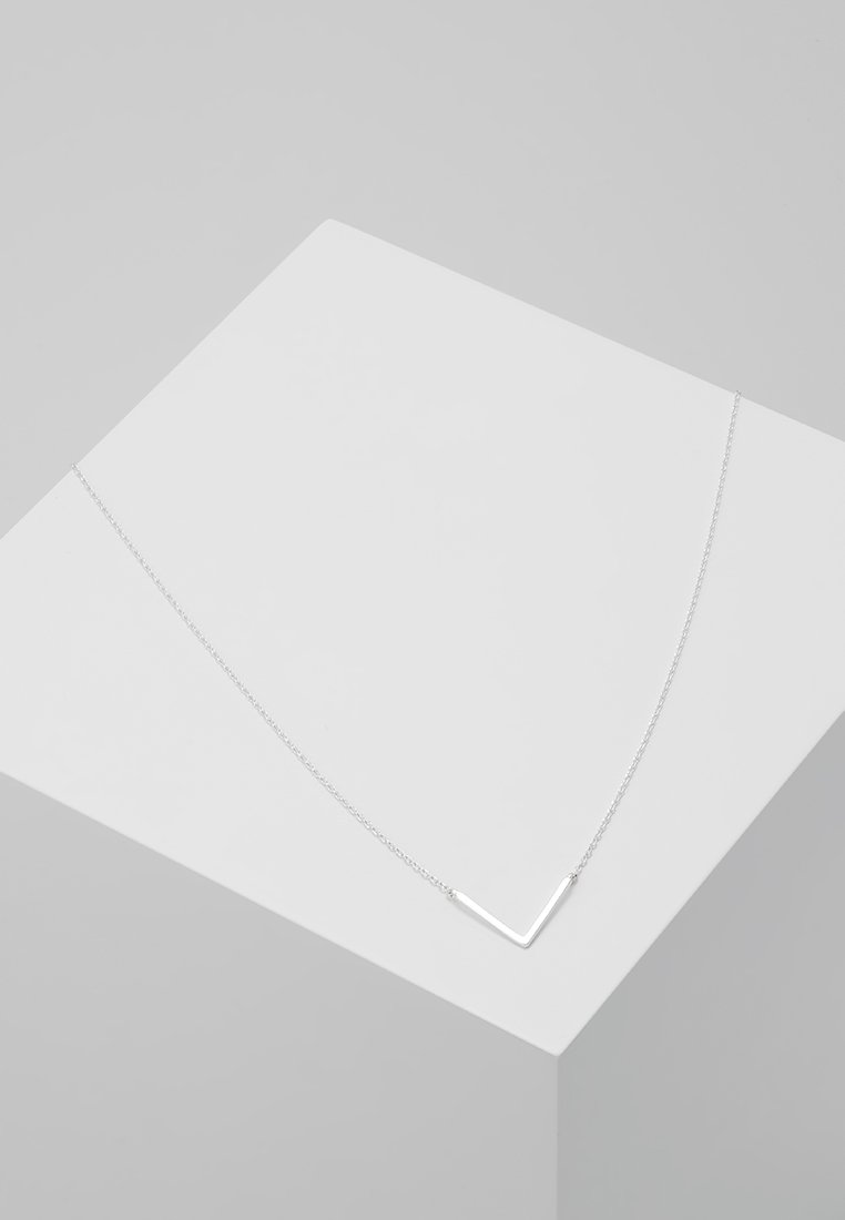 Collana argento a forma di V su una catena sottile, caratterizzata da un design elegante e minimalista con una finitura lucida. Mostrata su uno sfondo grigio chiaro.