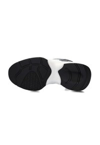 Zwart-witte zool van een sportschoen met een getextureerde rubberen grip, gebogen ontwerp en verhoogde accentpatronen voor grip en ondersteuning.