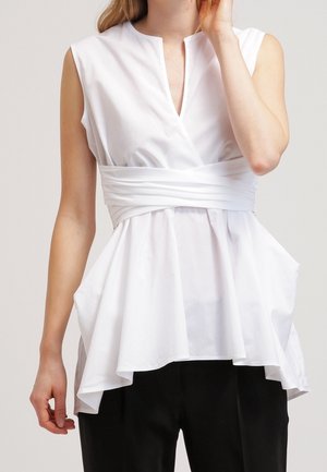 Weißes Peplum-Top mit hohem Ausschnitt, kurzen Ärmeln und Wickeldetail an der Taille. Verfügt über einen fließenden, strukturierten Saum. Wird mit dunkler Hose getragen.