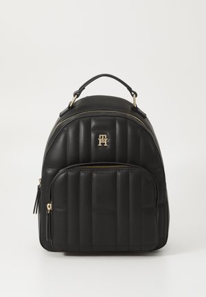 Black leather backpack with quilted design, gold hardware, and a front zip pocket. Features a top handle and adjustable shoulder straps.