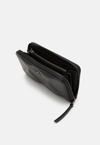 Black wallet made of textured leather, featuring a zip closure, multiple compartments, and a sleek design with contrasting hardware accents.