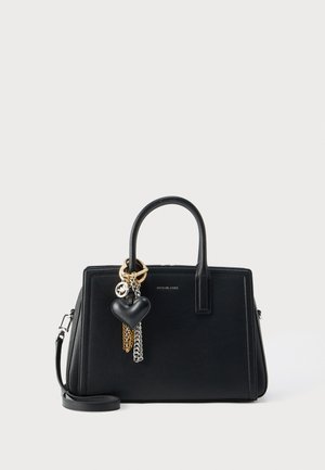Sac à main en cuir noir Michael Kors avec des poignées supérieures, une bandoulière amovible et un porte-bonheur en forme de cœur avec des chaînes dorées et argentées.