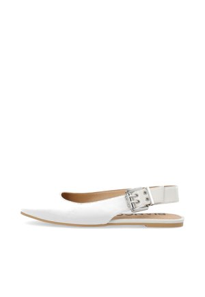 Zapato plano blanco con talón descubierto, puntera puntiaguda y tira con hebilla plateada sobre una suela de color tostado claro.