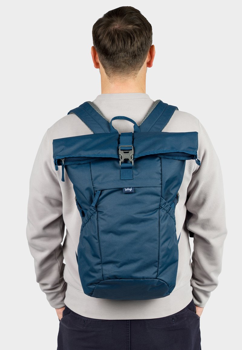 Navy blue roll-top backpack with adjustable straps, side pockets, and a sturdy buckle closure. Made of textured fabric with logo detail.