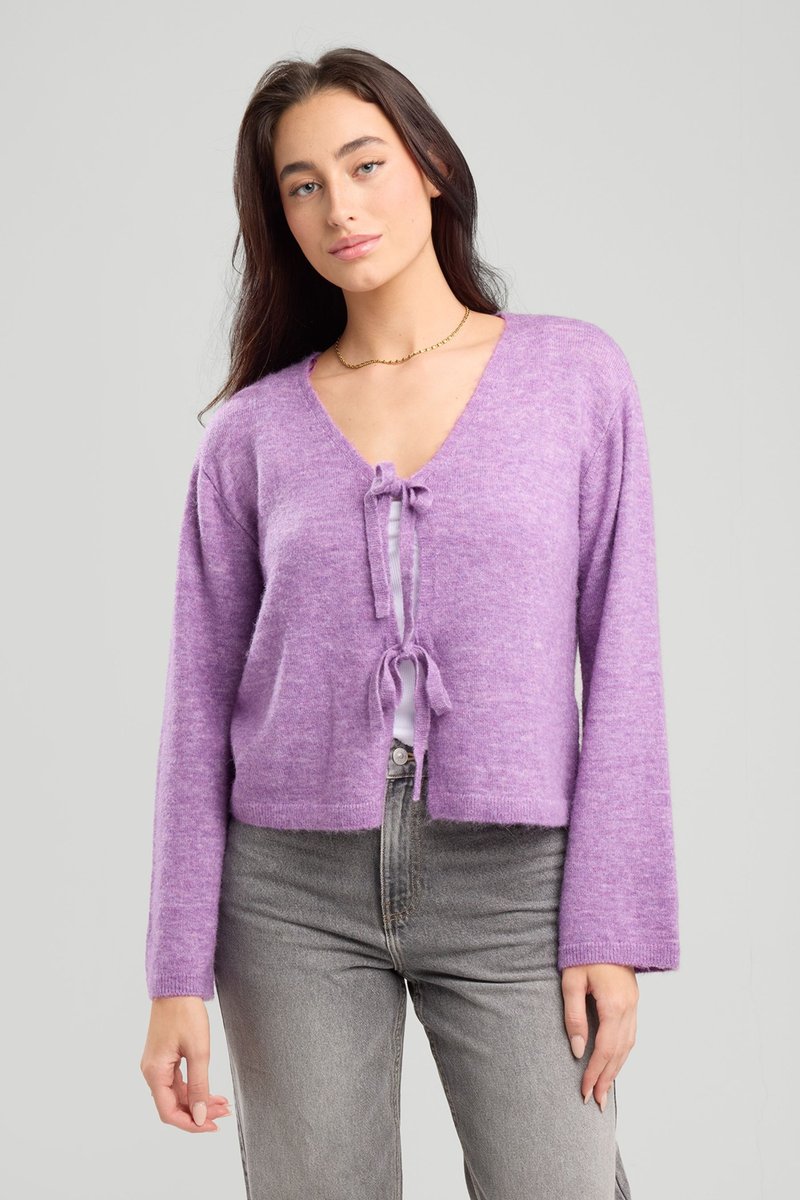 Purple cropped cardigan with a V-neck, drawstring front, long sleeves, and soft texture, paired with grey high-waisted jeans.