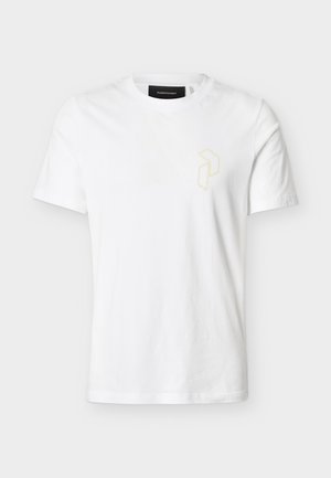 Balta īsroku T-krekls ar apaļu kakla izgriezumu, kreisajā krūtīs ar nelielu smalku bēša ģeometrisku logotipu, attēlots uz vienkārša fona.