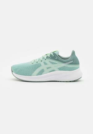 Chaussure de sport en mesh vert clair avec semelle blanche rembourrée et lacets vert clair, vue de côté sur un fond blanc uni.