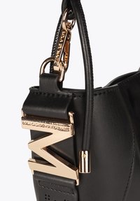 Czarna skórzana torebka z akcentem z geometrycznego sprzętu w kolorze złotym i krótkim, odczepianym paskiem, z detalami szewnymi i gładką teksturą.