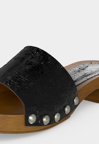 Sandale noire texturée à enfiler avec semelle en bois et détails de rivets argentés sur la bride avant, dotée d'un petit talon large.