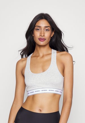 Bralette de algodón gris claro con escote redondo, tirantes anchos y una banda elástica de marca en color contrastante en el dobladillo. Textura suave.