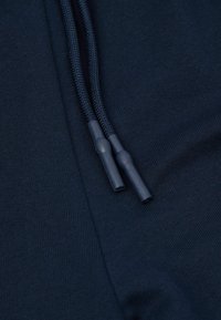 Marineblauwe hoodie-stof met een gestructureerd oppervlak; voorzien van verstelbare, gevlochten trekkoorden met plastic uiteinden.