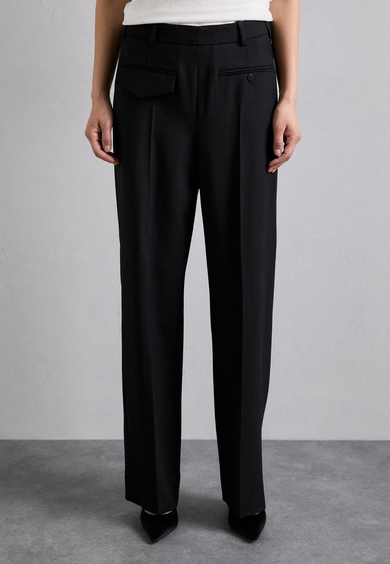 Black trousers with a tailored fit, featuring front pleats, a button closure, waistband loops, and two back pockets. Smooth fabric texture.