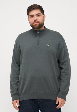 Mörkgrå tröja med halvdragkedja i kragen, ribbade manschetter och nederkant, med en liten gul logotyp på vänster bröst. Mjuk tygkvalitet.