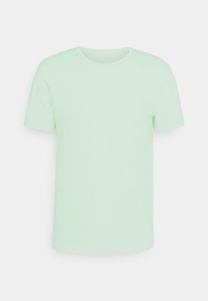 T-shirt à manches courtes vert menthe clair en tissu doux. Encolure ras du cou avec un discret détail de logo sur la poitrine. Coupe standard.