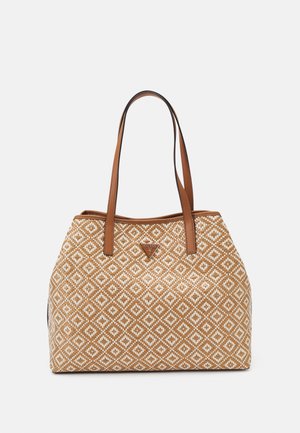 Sac cabas à motif beige et blanc avec deux poignées en cuir marron et un petit logo triangulaire Guess au centre devant.