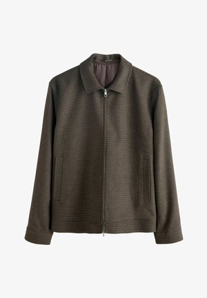 Hnědá zipová bunda s texturovaným kostkovaným vzorem, featuring klasický límec, dvě boční kapsy a rovný střih. Přední zipové zapínání.