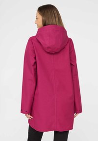 Abrigo impermeable fucsia con capucha, mangas largas y acentos de botones en los puños, que cuenta con una textura suave y un diseño de corte recto.