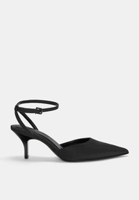 Črne slingback pete s koničastim nosom, izdelane iz gladkega materiala, z ozkim paščkom okoli gležnja in 5 cm visokimi stiletto petami.