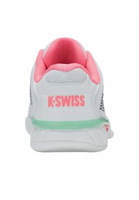 K-Swiss cipela s bijelim tekstilnim gornjištem, ružičastim akcentima na ovratniku, mrežastim detaljima i zelenom gumiranom potplatu. Ima logotip na stražnjem dijelu.