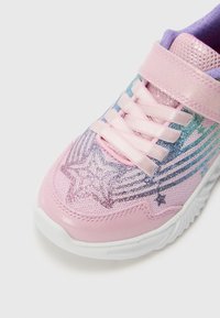 Rosa Sportschuh mit glitzerndem Sterndesign, Netzstruktur und pastellblauen Akzenten. Mit flachen Schnürsenkeln und einer weißen Gummisohle.