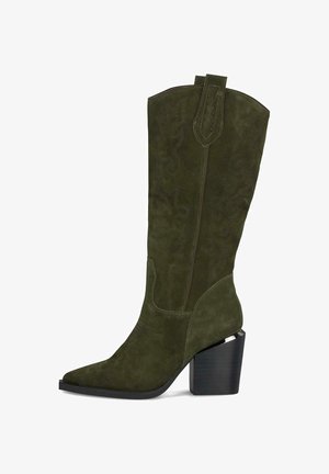 Botte de cowboy en nubuck vert avec un bout pointu, hauteur mi-mollet, couture décorative et un talon bloc. Présente une languette de tirage en haut.