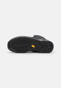 Semelle de chaussure de randonnée noire, dotée d'un motif de bande de roulement en caoutchouc texturé pour une meilleure adhérence, logo Vibram et capuchon renforcé pour la durabilité.