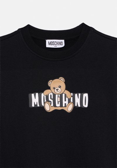 Czarna bluza dziecięca z grafiką brązowego misia i białym napisem "MOSCHINO" częściowo zakrytym przez misia na piersi.