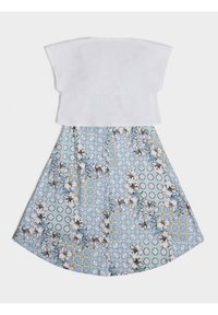 White cropped top with wide sleeves above a flared skirt featuring a blue floral and geometric pattern, highlighting yellow and green accents.