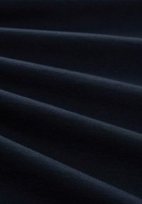 Donkerblauwe stof met een gladde textuur, met diepe plooien die subtiele schaduwen creëren, consistent in kleur en materiaal.