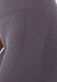 Leggings viola con una texture liscia e elastica e una vita elasticizzata. Il tessuto presenta un motivo a maglia fine con una leggera lucentezza.