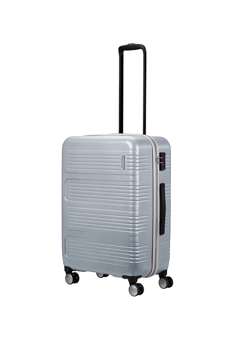 Maleta rígida plateada con estrías verticales, asa negra extensible y cuatro ruedas giratorias. Cierre con cremallera y asa lateral para facilitar su transporte.