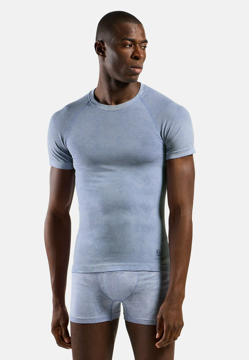 Light blue, fitted short-sleeve compression top made of mesh fabric; paired with matching fitted shorts, both showing subtle patterns.