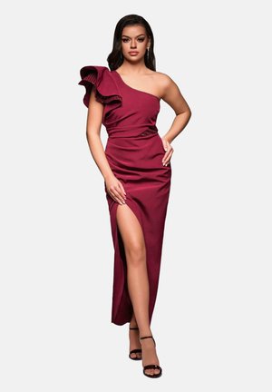 Vestido burdeos de un solo hombro con un hombro voluminoso, abertura hasta el muslo y cintura ajustada. Tejido suave con un diseño drapeado. Tacones negros con tiras.