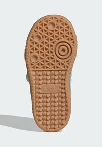 Gumená podrážka tenisky so štruktúrovaným vzorom; obsahuje kruhové a trojuholníkové motívy; svetlá béžová farba s vyrazeným logom "adidas".